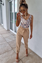 Canotta Moda-Mania con scollo a V, tessuto elasticizzato a fantasia zebrata su sfondo beige, elegante e comoda.