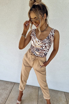 Canotta Moda-Mania con scollo a V, tessuto elasticizzato a fantasia zebrata su sfondo beige, morbida e aderente.