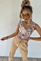 Canotta Moda-Mania con scollo a V in tessuto elasticizzato a fantasia zebrata su sfondo beige, dettaglio di stile e comfort