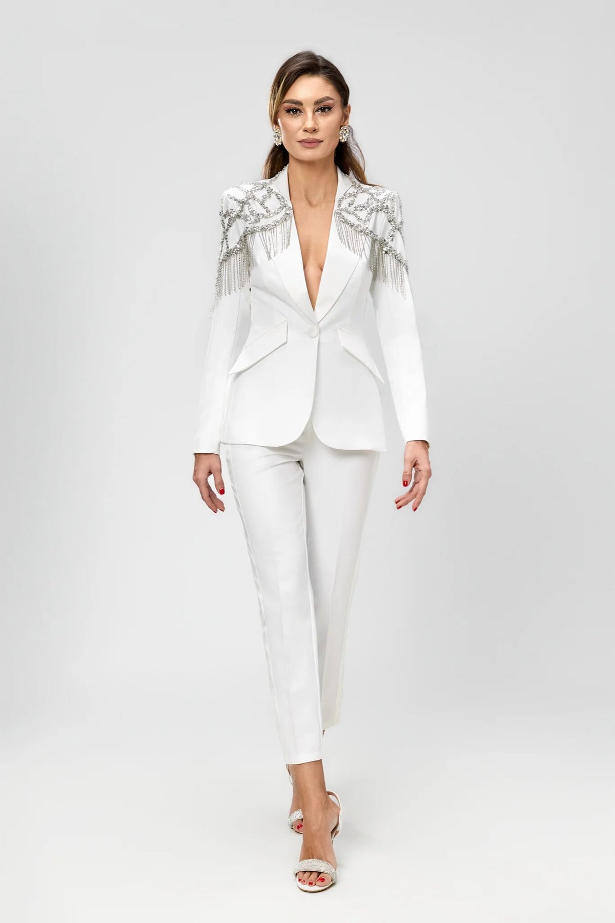 Completo elegante bianco Bby con giacca decorata da frange di cristalli e paillettes argento, pantaloni a sigaretta raffinati.