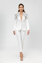 Completo elegante bianco Bby con giacca decorata da frange di cristalli e paillettes argento, pantaloni a sigaretta raffinati.