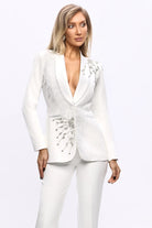 Completo tailleur bianco Bby con giacca a V con applicazioni di piume argento e pantaloni a gamba larga.