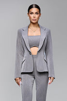 Completo tailleur a tre pezzi Bby, giacca e pantaloni grigi con dettagli a righe sottili e piccoli strass, stile elegante.