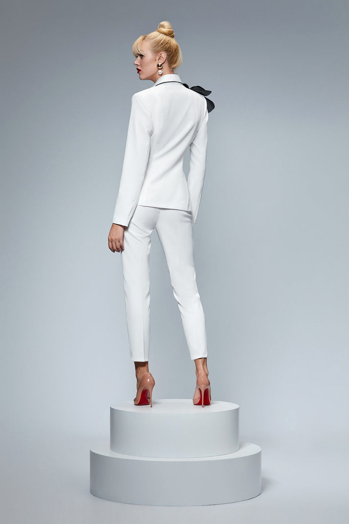 Completo tailleur bianco Bby giacca doppiopetto accessoriata con spilla a fiore nera e pantaloni a sigaretta