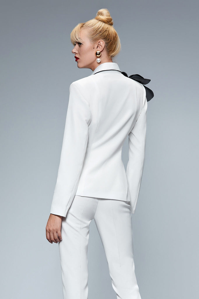 Completo tailleur bianco Bby giacca doppiopetto accessoriata con spilla a fiore nera e pantaloni a sigaretta