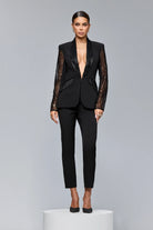 Completo tailleur nero Bby con giacca a maniche lunghe in tulle, decorazioni in paillettes, perline e pantaloni a sigaretta.