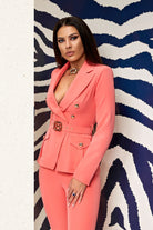 Completo tailleur elegante salmone Bby, giacca e pantalone con cintura e fibbia dorata, stile raffinato e moderno.