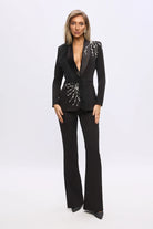 Completo tailleur nero Bby con giacca a V con piume e applicazioni argento, pantaloni a gamba larga, eleganza moderna.