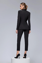 Completo tailleur nero Bby con giacca decorativa dorata e perline nere, pantaloni a sigaretta eleganti e raffinati.