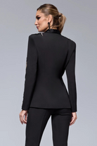 Completo tailleur nero Bby con giacca decorativa dorata e perline nere, pantaloni a sigaretta eleganti e moderni.