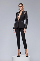 Completo tailleur nero Bby con giacca decorativa dorata e perline nere, pantaloni a sigaretta eleganti e moderni.