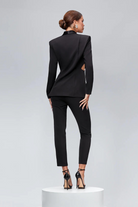 Completo tailleur nero Bby con decorazioni argento, volant, fiocco e cut-out in vita, giacca e pantalone eleganti.
