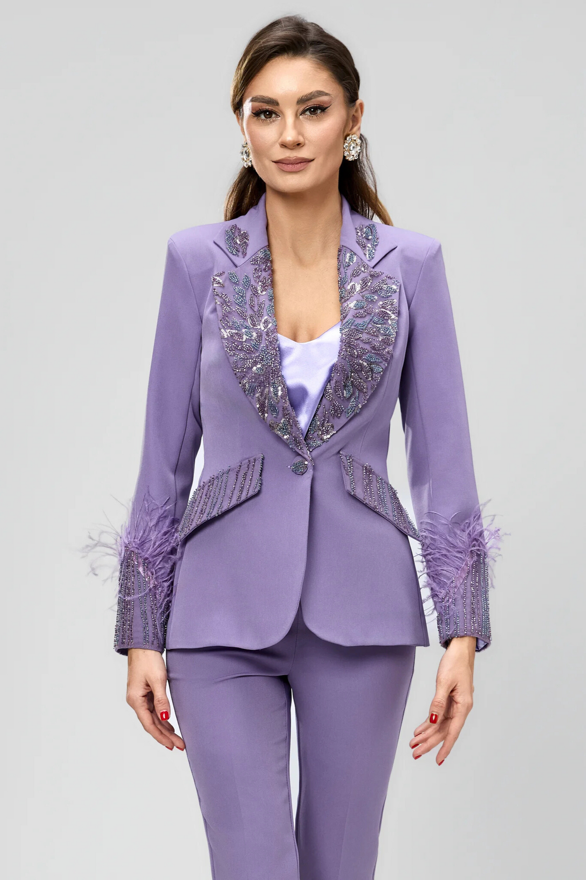 Completo tailleur Bby lilla con giacca impreziosita da piume e ricami in perline, con pantaloni a sigaretta eleganti e raffinati.