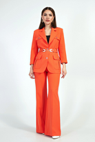 Completo tailleur arancione corallo Moda-Mania con giacca con tasche, cintura e pantaloni larghi, stile elegante e alla moda.