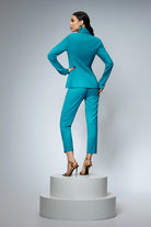 Completo tailleur Bby turchese con giacca doppiopetto, pantaloni e bottoni metallici dorati, stile elegante e moderno.