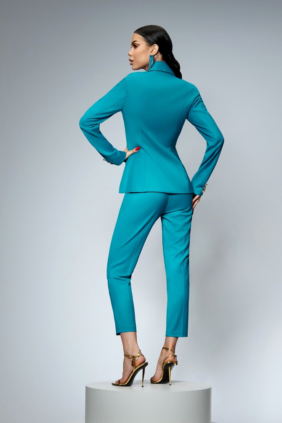 Completo tailleur turchese Bby con giacca doppiopetto e pantaloni, dettagliato con bottoni metallici dorati.