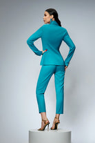 Completo tailleur turchese Bby con giacca doppiopetto e pantaloni, dettagliato con bottoni metallici dorati.