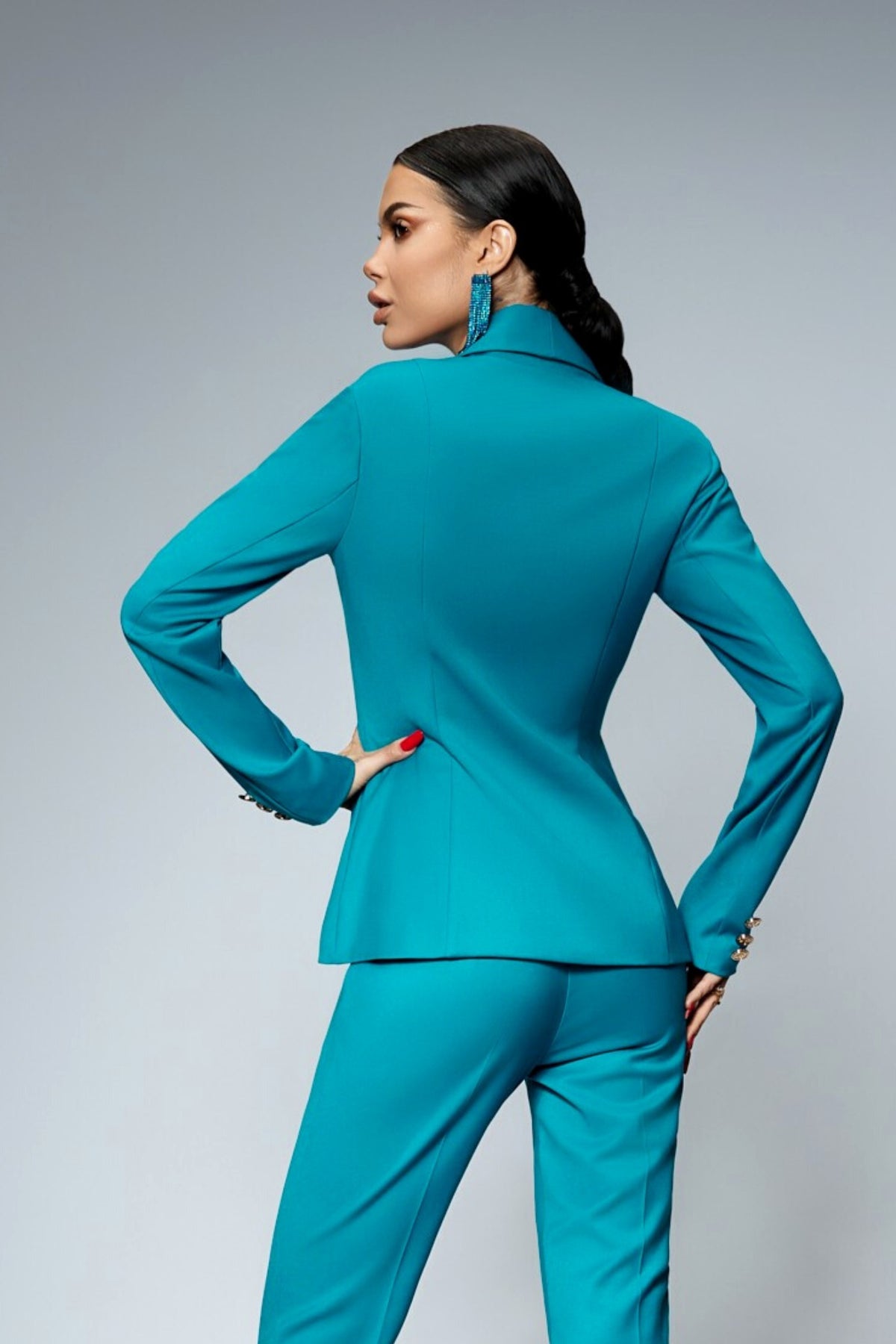Completo tailleur Bby turchese con giacca doppiopetto e pantaloni, accessoriato con bottoni metallici dorati.