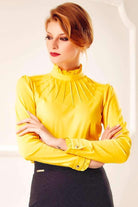 Camicia gialla Fofy con collo alto, maniche lunghe, polsini, bottoni dorati e dettagli arricciati, stile elegante e moderno