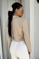 Giacca beige casual elegante corta in vita Moda-Mania con un bottone, scollo a V e revers, vista frontale.