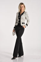 Giacca da tailleur grigia in tessuto bouclé Moda-Mania con rifiniture in velluto nero e bottoni gioiello eleganti.