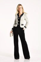 Giacca da tailleur grigia in tessuto bouclé Moda-Mania con dettagli in velluto nero e bottoni gioiello eleganti.