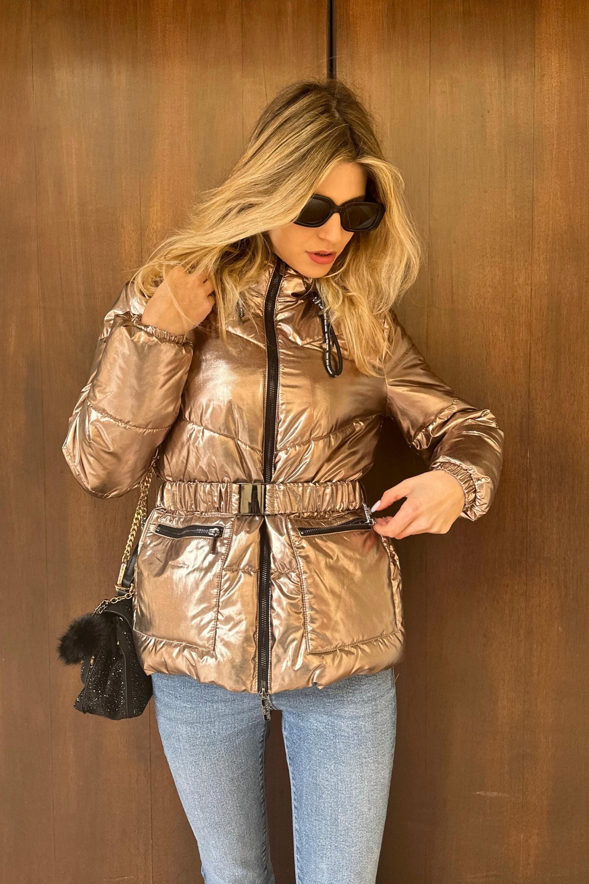 Giacca invernale Denny Rose bronzo laminato con cappuccio, cintura e dettagli portafoglio, stile elegante e alla moda.