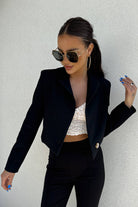 Giacca nera casual elegante in vita, corta, con scollo a V, revers e un bottone, marca Moda-Mania, immagine frontale.