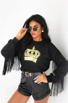 Maglia felpa nera casual di Moda-Mania con stampa dorata, logo corona, maniche lunghe e frange decorative nere, stile sportivo.