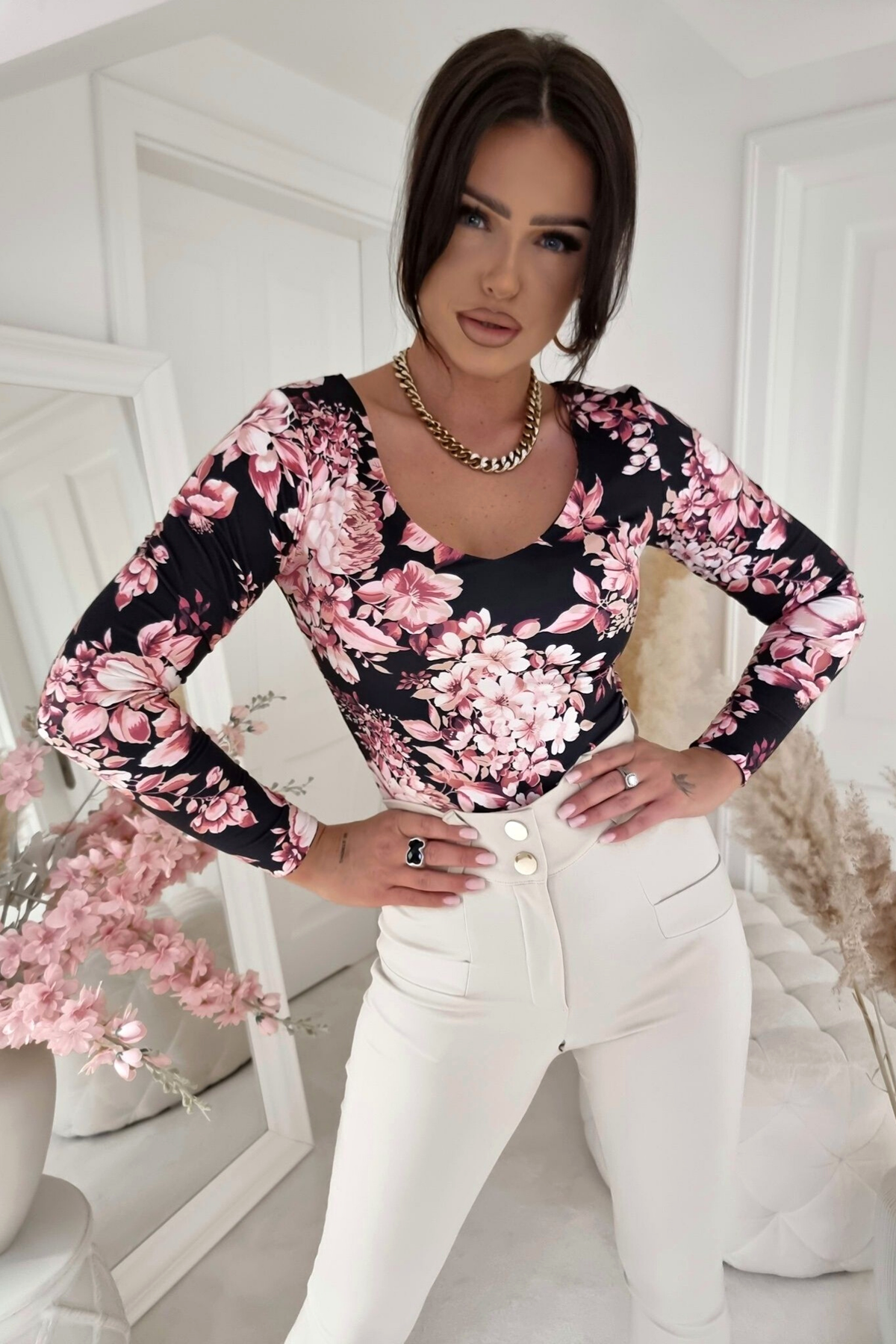Maglia nera a stampa floreale rosa con scollo a V reversibile, marca Moda-Mania, dettaglio di tessuto e design elegante