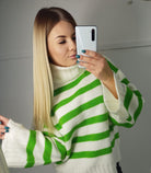 Maglione oversize bianco avorio con righe verdi, collo alto e maniche larghe, marca Moda-Mania, tessuto morbido e comodo.