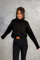 Maglione oversize nero in filato morbido con trecce, collo alto e polsini a coste, di Moda-Mania, stile caldo e confortevole.