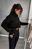 Maglione oversize nero in filato morbido con trecce, collo alto e polsini a coste, di Moda-Mania.