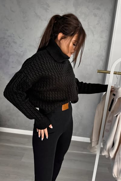 Maglione oversize nero in filato morbido con trecce, collo alto e polsini a coste, di Moda-Mania.
