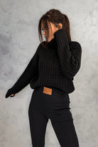Maglione oversize nero in filato morbido con trecce, collo alto e polsini a coste, marca Moda-Mania.