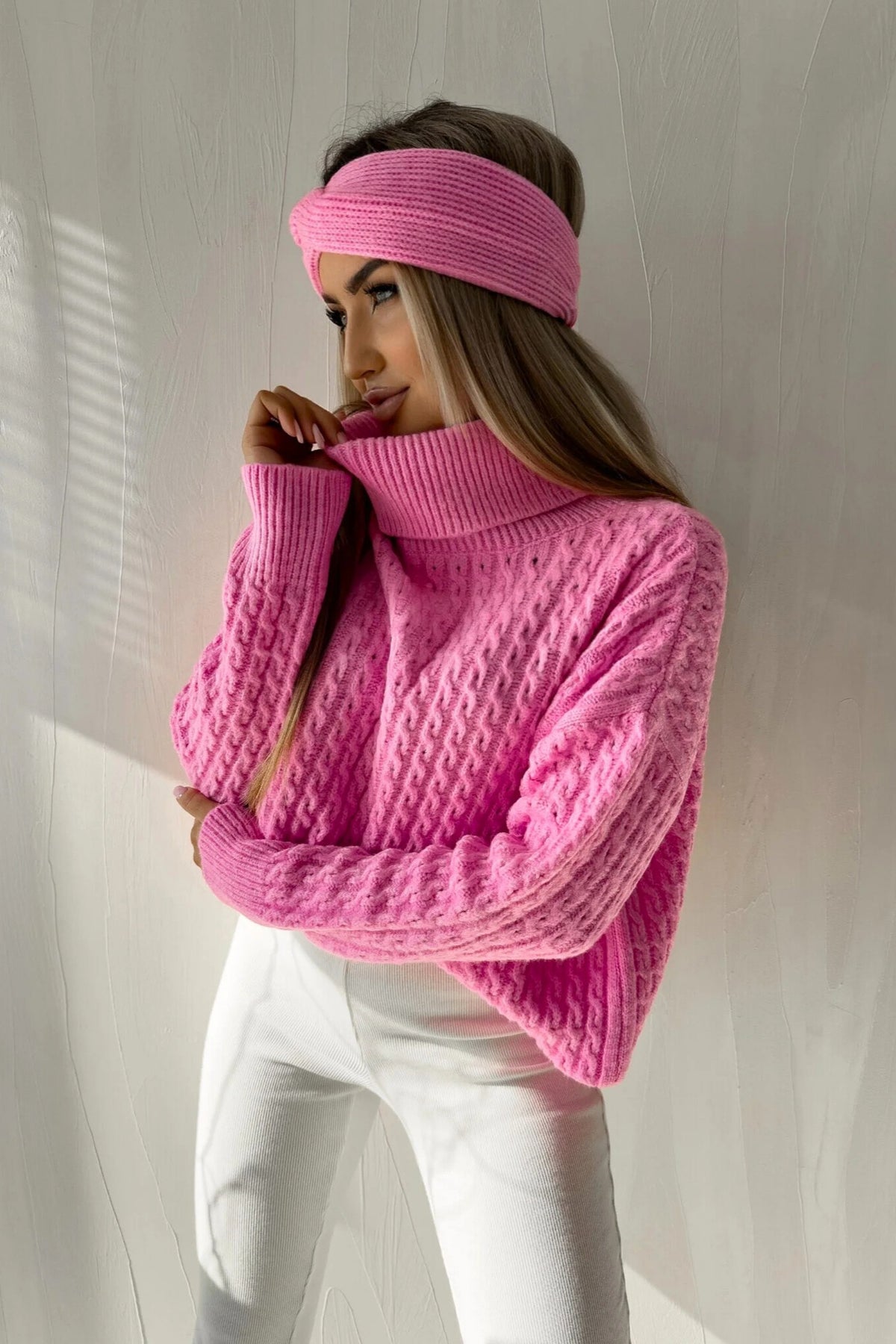 Maglione oversize rosa pink in filato soffice con trecce, collo alto e polsini a coste, prodotto Moda-Mania.