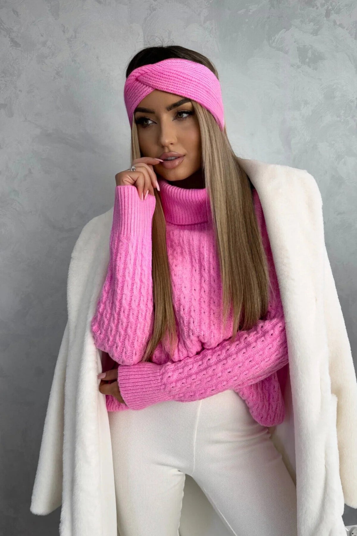Maglione oversize morbido Moda-Mania a trecce rosa pink con collo alto e polsini a coste, in filato soffice, visibile in dettaglio.