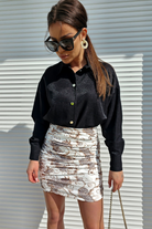 Minigonna bianca corta a vita alta aderente con fantasia damascata beige e arricciature, marca Moda-Mania.