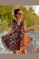 Abito estivo corto casual Moda Mania con fantasia leopardata, scollo a V e dettagli di ruches, indossato su una modella.