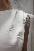 Abito svasato bianco Moda-Mania con gonna a ruota satinata, dettagli in pizzo e cintura inclusa, abiti corti eleganti.