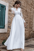 Abito lungo svasato bianco Moda-Mania con spacco laterale e corpetto in tulle ricamato, elegante e femminile.