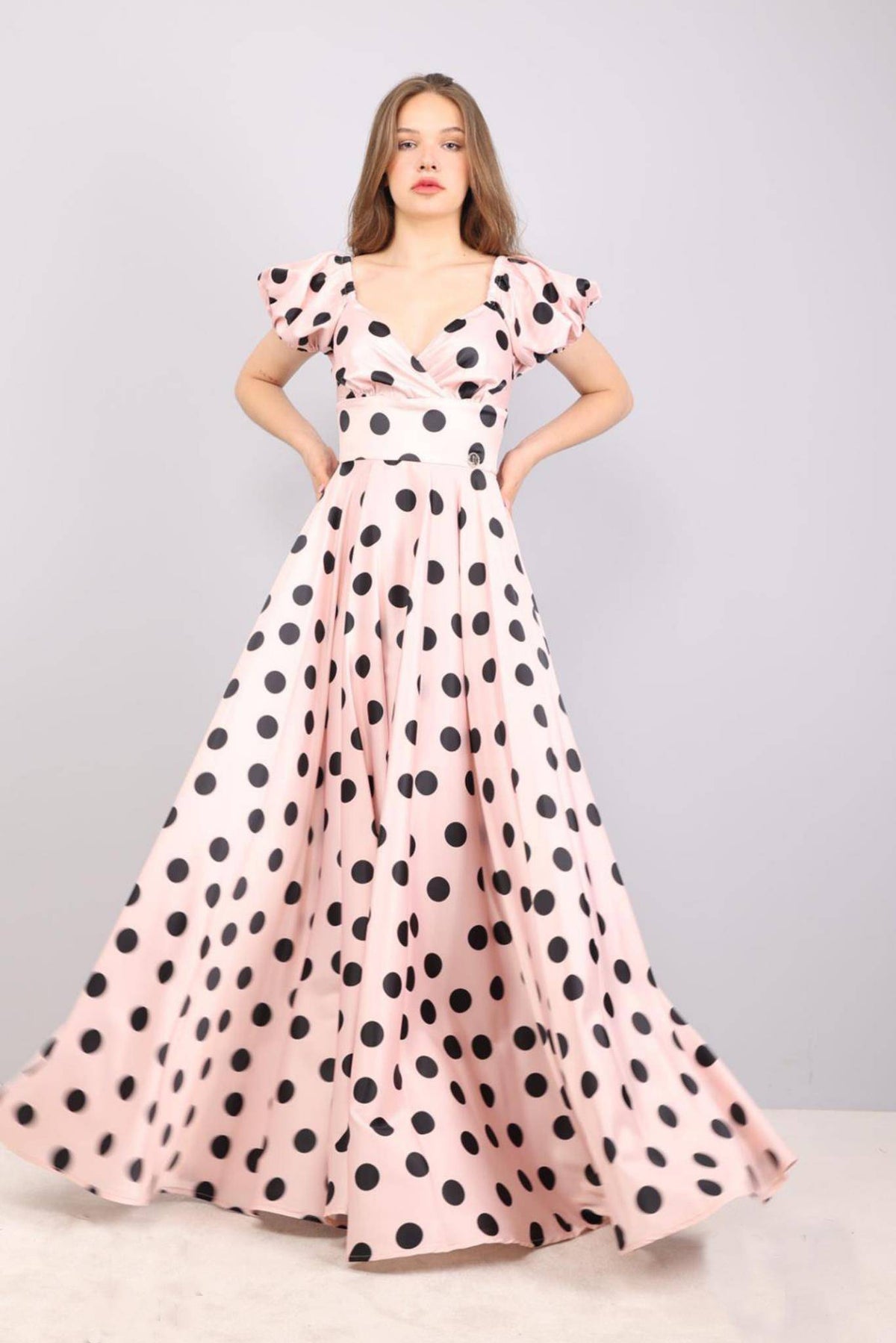 Abito lungo svasato rosa con pois neri, scollo a cuore e maniche a sbuffo in tessuto taffetà, firmato Moda-Mania.