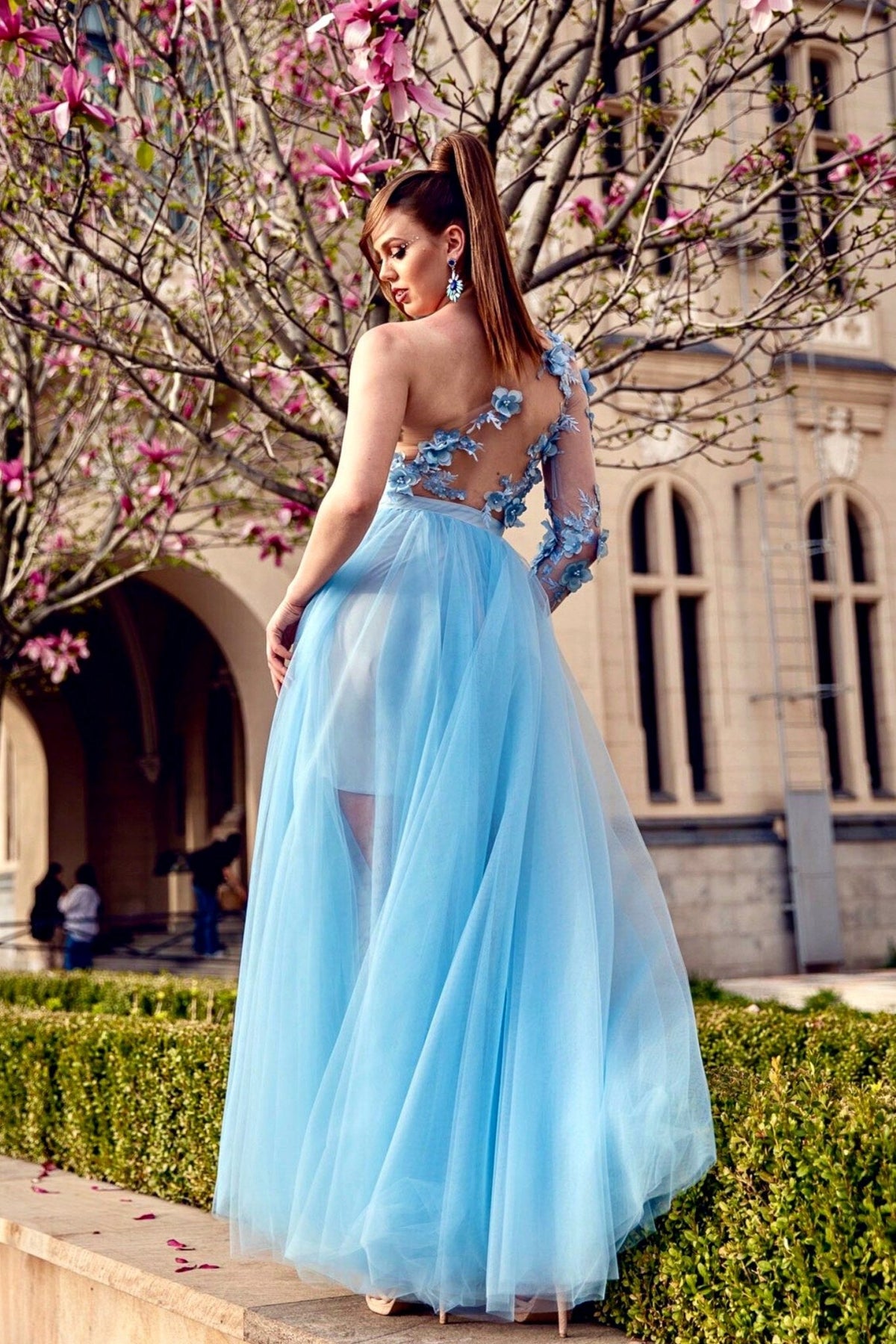 Abito corto celeste a fiori con una manica, gonna lunga e ampia in tulle, marca Moda-Mania, stile elegante e femminile.