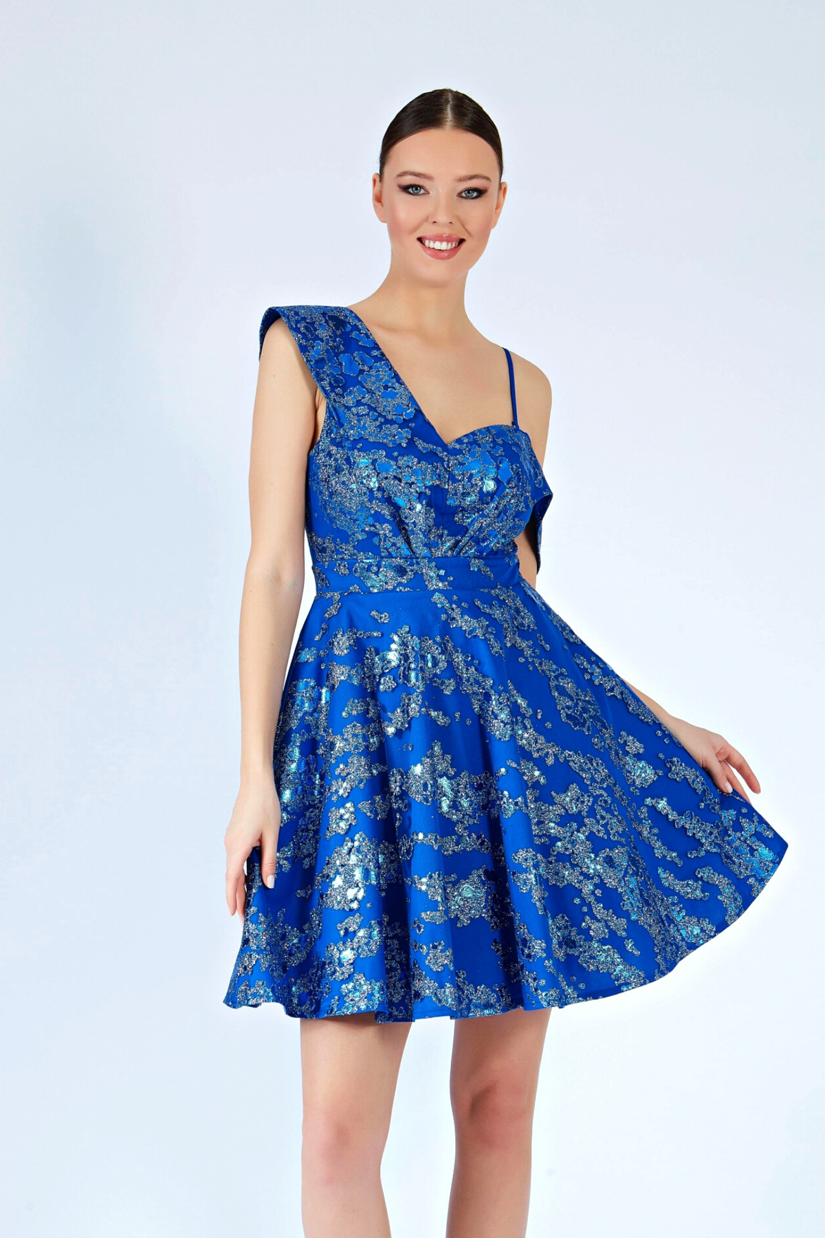 Abito corto svasato blu elettrico con fantasia glitterata e spalla cadente, moda-manìa, perfetto per occasioni estive.