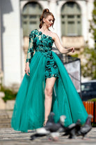 Abito corto verde smeraldo con fiori, manica mono e gonna lunga ampia in tulle, moda a firma Moda-Mania.