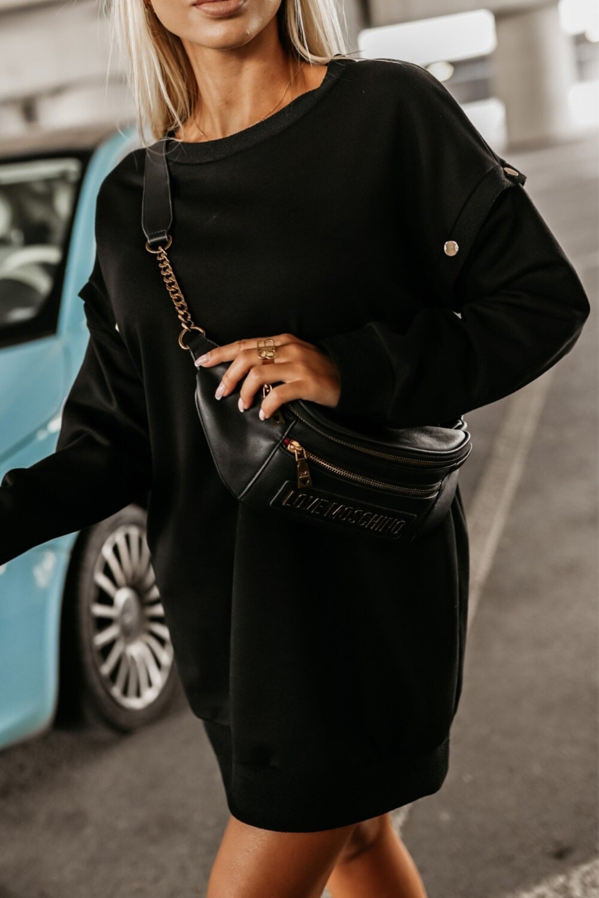 Abito felpa nero in cotone con maniche lunghe staccabili, taglio dritto e tasche laterali nascoste, stile denim e sportivo.