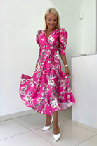 Abito midi fucsia svasato con fantasia floreale, maniche a sbuffo e vita allacciabile, brand Moda-Mania.