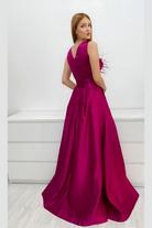 Abito lungo da cerimonia svasato magenta Axa con spacco laterale, corpetto con piume e fiori 3D, moda elegante da evento