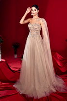 Abito lungo nude da cerimonia Moda-Mania, svasato con corpetto monospalla a cuore, decorazioni in paillettes e gonna ampia in tulle.