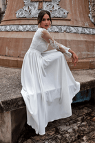 Abito lungo svasato bianco Moda-Mania con spacco laterale e corpetto in tulle ricamato, elegante e raffinato.